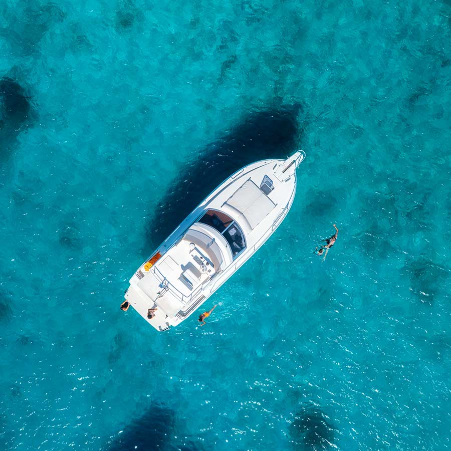 Boat at sea with people swimming