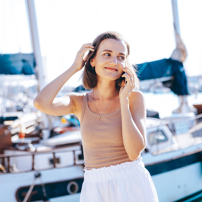 Girl on the phone near a yacht
