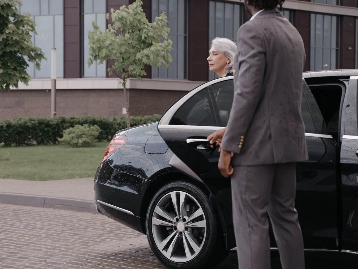 Chauffeur opening the car door for a client